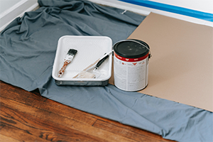 Grey paint pan and can sitting on home floor