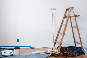 Home interior with ladder and painting supplies