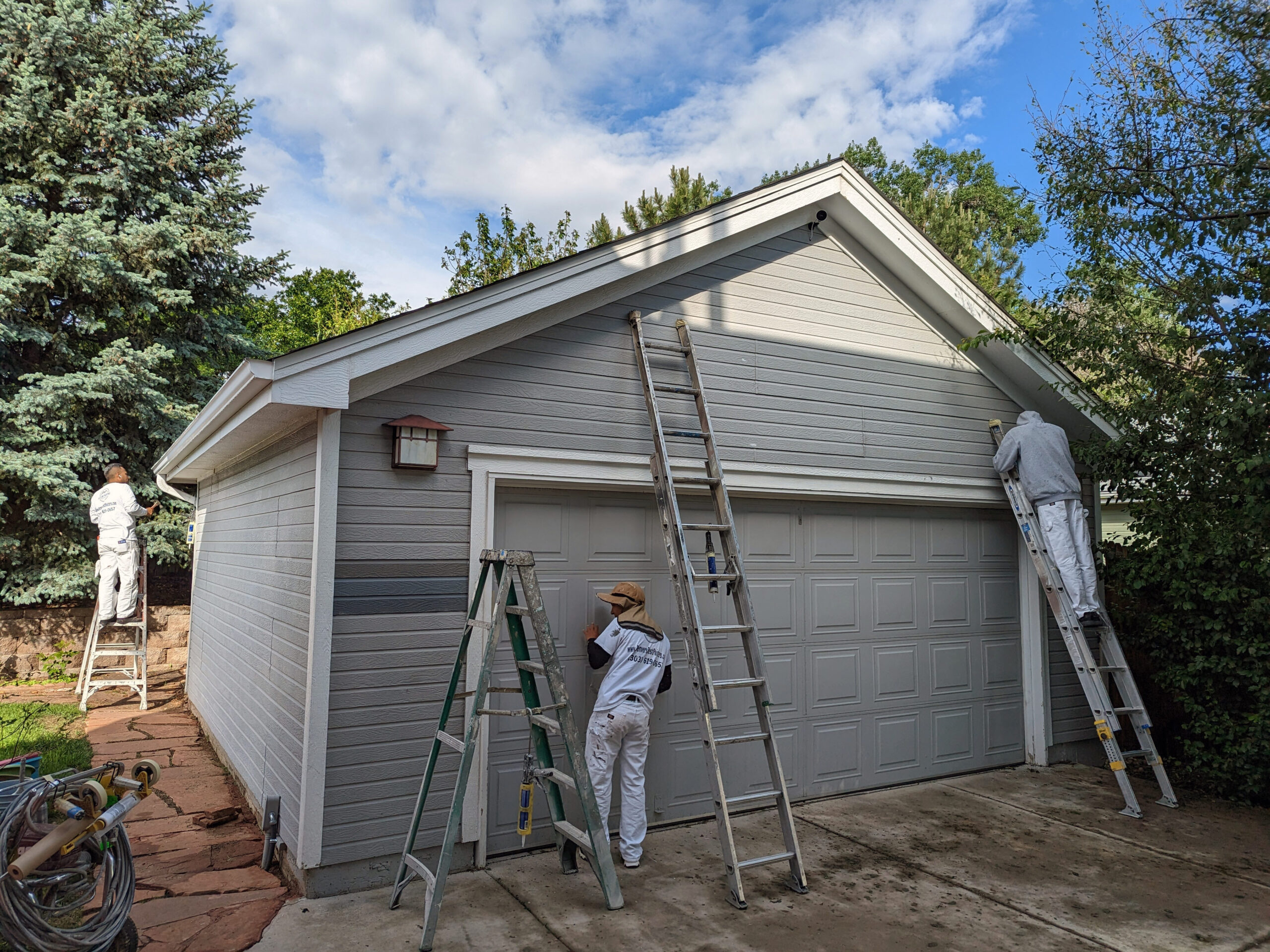 Accent Painting crew priming and painting an exterior garage building