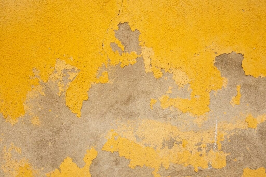 Denver's harsh elements Close-up image of exterior wall paint severely peeling and deteriorating, illustrating the impact of Denver's harsh weather elements